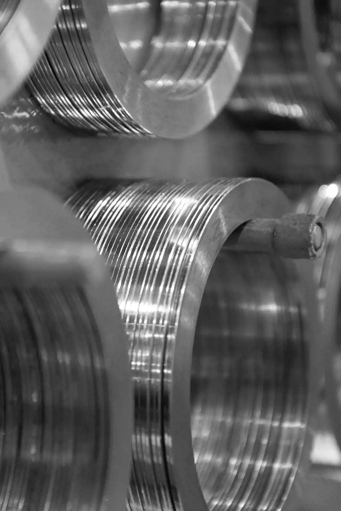 Close up of multiple smaller coils of steel, displayed on a rack